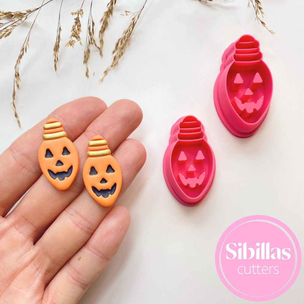 Halloween-themed cookie cutters held by a hand on a light background with 'Sibillas cutters' branding.