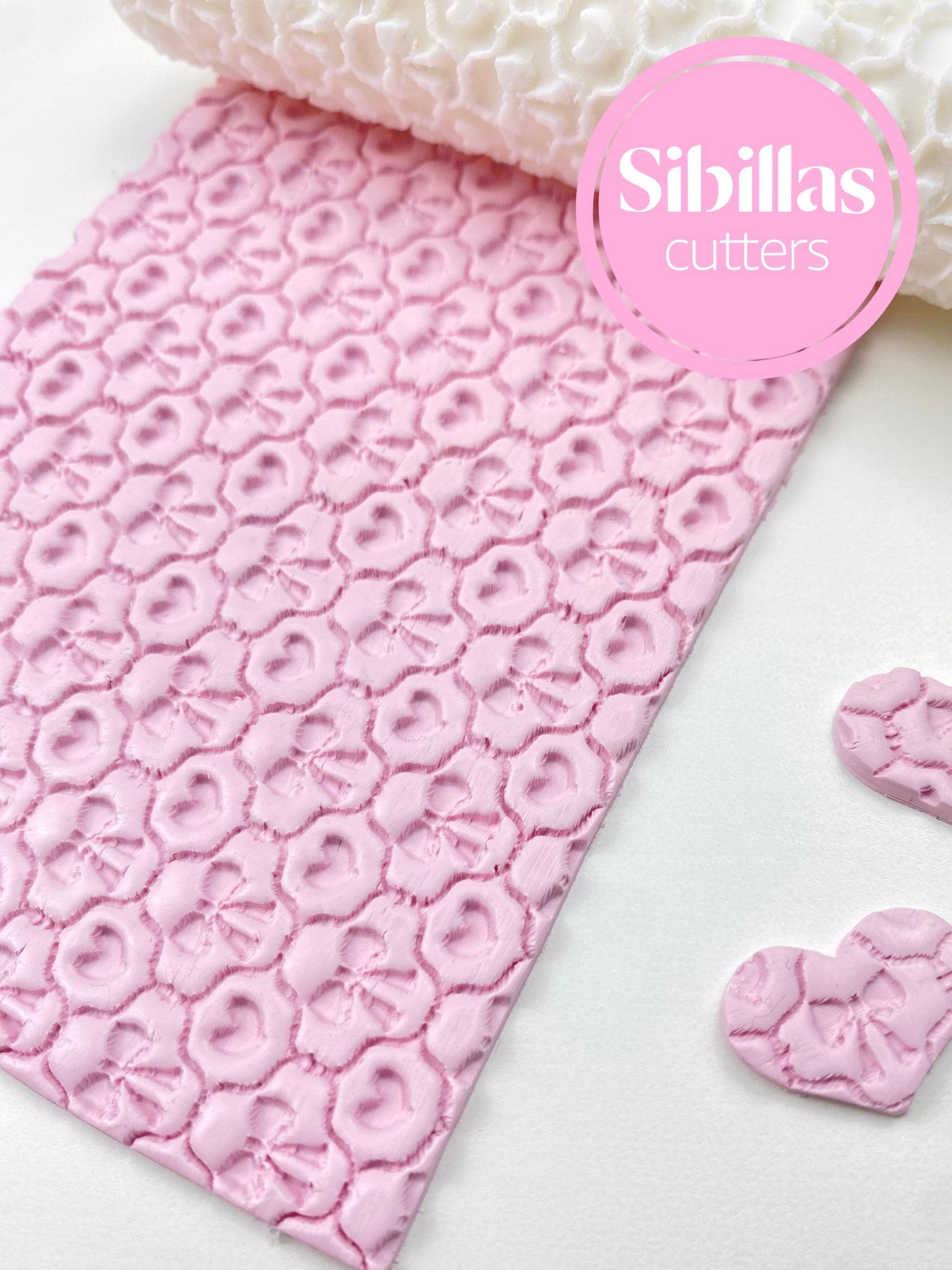 Embossed clay roller for ceramics featuring hearts and bow designs