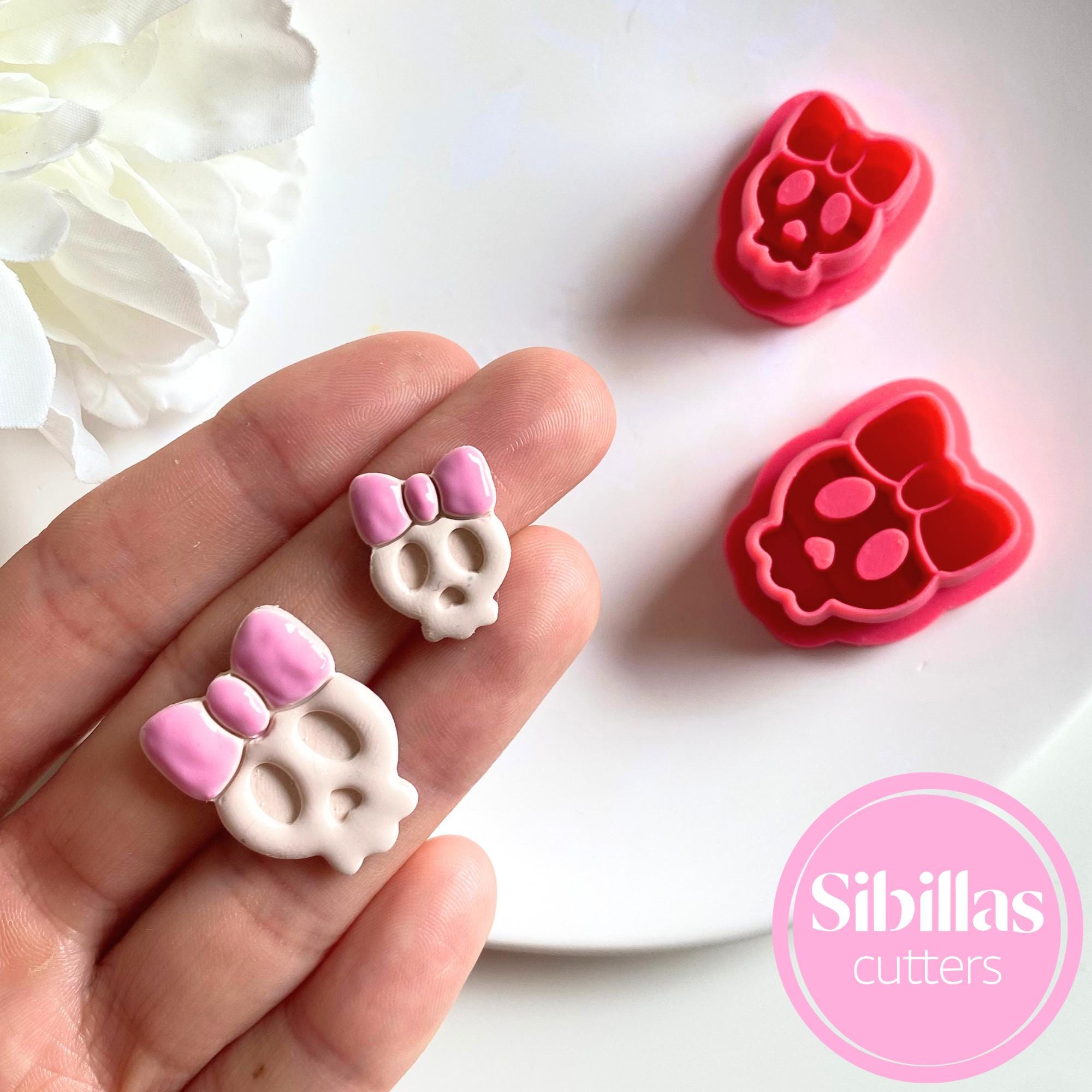 Polymer clay cutter shaped like a skull with a bow for spooky earrings and charms