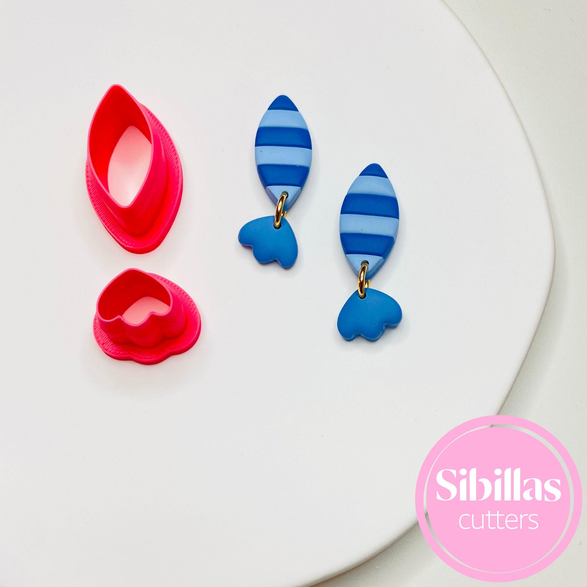 Colorful fish-shaped cookie cutters on a white plate with 'Sibillas Cutters' branding.