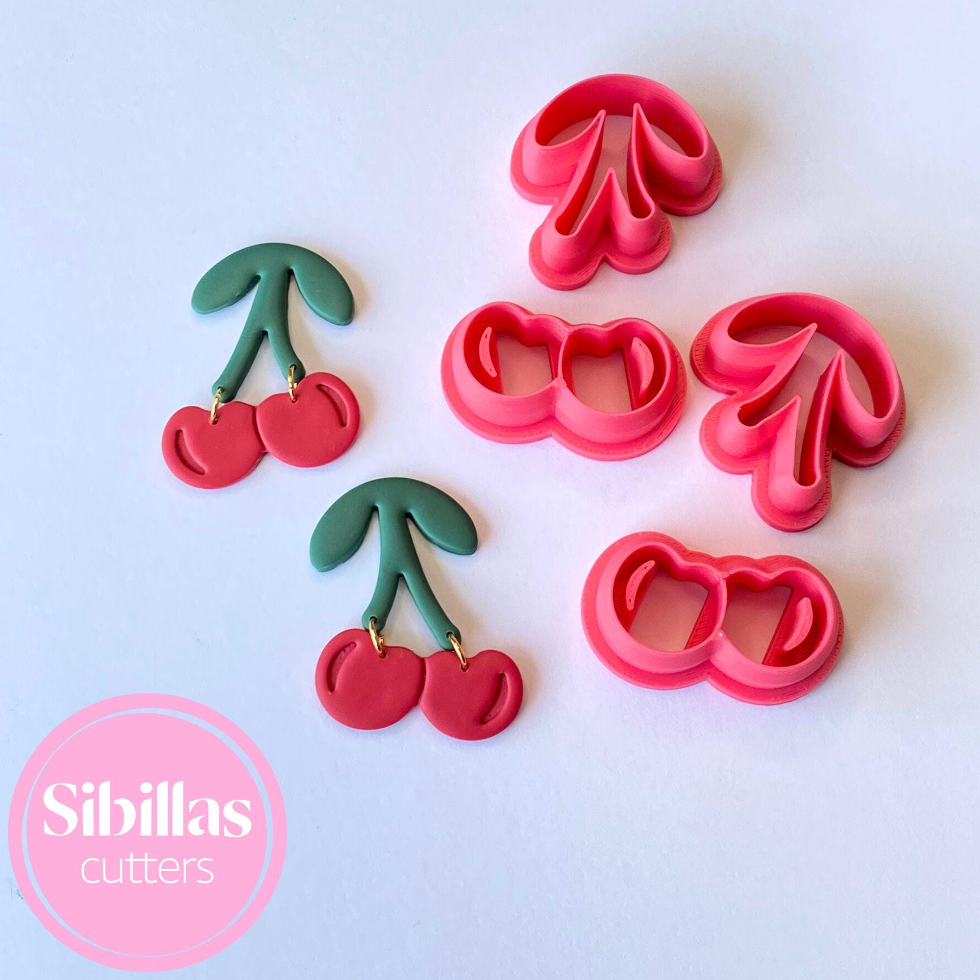 Set of cookie cutters shaped like cherries and leaves on a white background with 'Sibillas Cutters' branding.