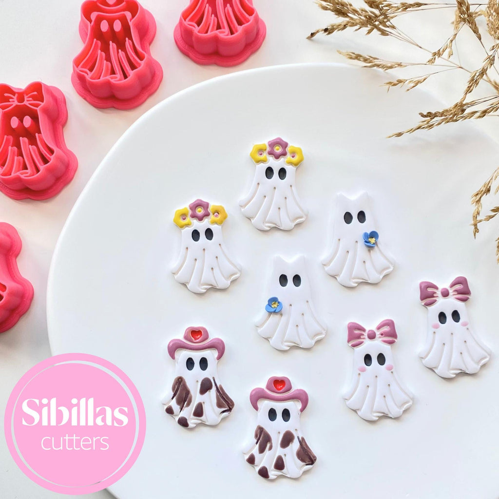 Decorative ghost cutters with colorful designs on a white plate, branded 'Sibillas cutters'.