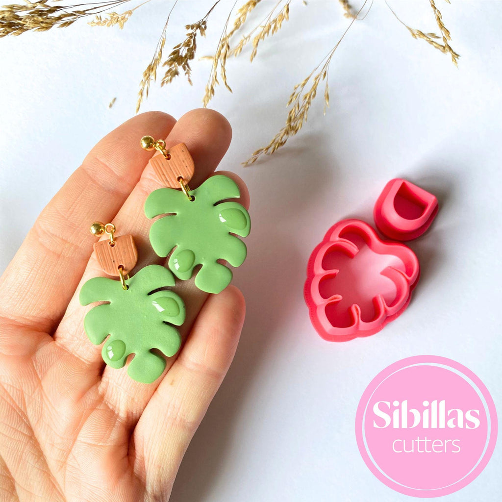 Green leaf-shaped cookie cutters held in a hand with a white background and 'Sibillas Cutters' branding.