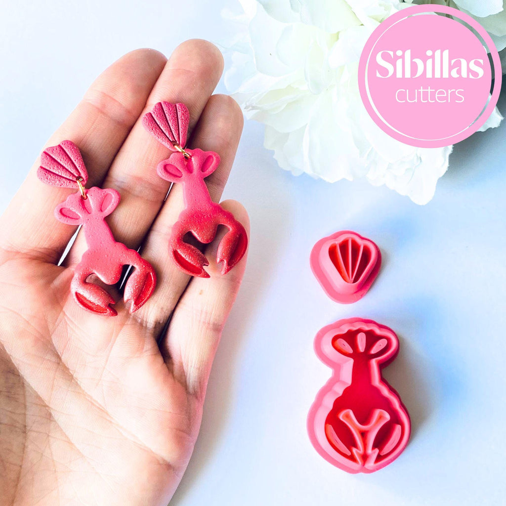Red lobster-shaped cookie cutters held in a hand with 'Sibillas cutters' branding.