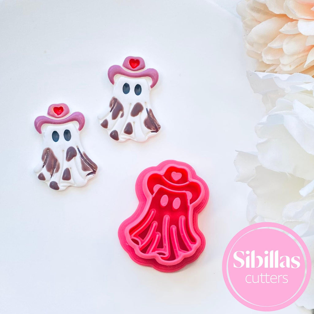 Cookie cutters shaped like ghosts with pink hair and hearts, on a white background with 'Sibillas cutters' branding.